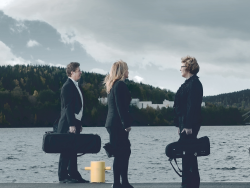 Kolme Jyväskylä Sinfonian muusikkoa seisoo satamassa soitinkoteloidensa kanssa.