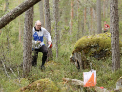 Kaapro Häkkinen lähestyy suunnistusrastia metsässä. Kuva Touho Häkkinen