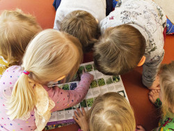 Lapset katsovat kirjaa. Kuva Riikka Kaakkurivaara