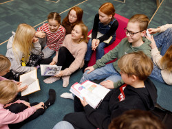 oppilaita lattialla istumassa kirjoja lukemassa. Kuva Hanna-Kaisa Hämäläinen