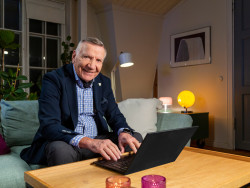 Mieshenkilö istuu sohvalla edessään pöydällä kannettava tietokone. Kuva Jyväskylän kulttuuripalvelut