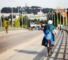 Pyöräilijä kulkemassa kaupunkimaisemassa. Kuva Helena Kujala